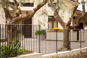 una valla frente a una casa con árboles en Al Borgo Rooms en Gradara