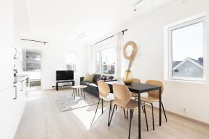 a white living room with a black table and chairs at Forenom Serviced Apartments Trondheim in Trondheim