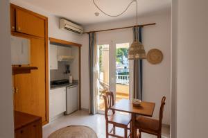 eine Küche und ein Esszimmer mit einem Tisch und einer Tür zu einem Balkon in der Unterkunft INNER Niza Paguera in Paguera