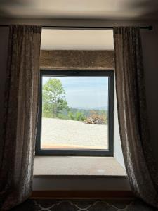 a window in a room with a view of a field at Casa do Borges 