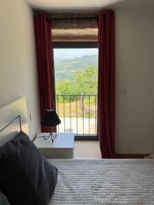 a bedroom with a bed and a window with a view at Casa do Borges 