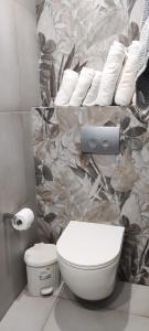 a bathroom with a toilet and towels on a wall at House Anna Sarti in Sarti