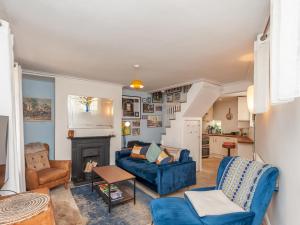 ein Wohnzimmer mit einem blauen Sofa und einem Kamin in der Unterkunft Pass the Keys Wonky Cottage with amazing garden in Leeds