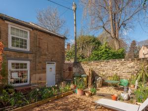 une maison en briques avec un jardin en face de celle-ci dans l'établissement Pass the Keys Wonky Cottage with amazing garden, à Leeds