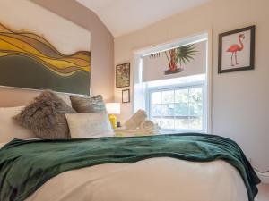 Schlafzimmer mit einem großen Bett und einem Fenster in der Unterkunft Pass the Keys Wonky Cottage with amazing garden in Leeds
