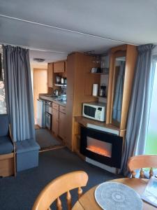 a kitchen with a living room with a fireplace at Happy Holiday Home in Warden