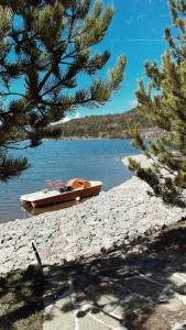 um pequeno barco sentado na margem de um lago em Resort Mezini em Ersekë