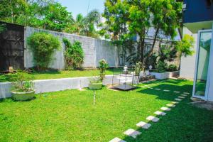 un patio con dos macetas en la hierba en Tranquill Villa La Dimora, en Gampaha