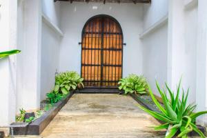 una puerta delantera de un edificio blanco con plantas en Tranquill Villa La Dimora, en Gampaha