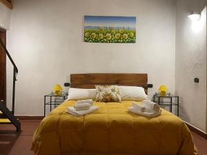 una camera da letto con un letto giallo con due asciugamani di AgriHouse Orvieto a Morrano