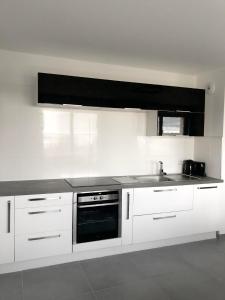 a white kitchen with a sink and a stove at Amazing Apartment Disneyland Paris in Chessy