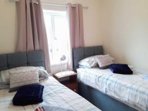 two beds sitting next to each other in a bedroom at Shirleys Cottage in Othery