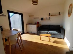 uma sala de estar com um sofá e uma mesa em petit Gîte T2 des balcons d'Ancenis em Ancenis