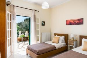 a bedroom with two beds and a sliding glass door at Ipsos & Barbati Panoramic Views by Konnect in Ipsos