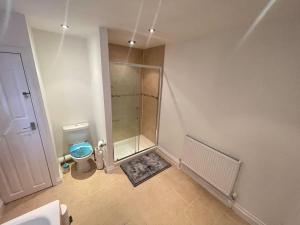 a small bathroom with a shower and a toilet at Impeccable 3-Bed Home Away From Home in Swindon in Swindon