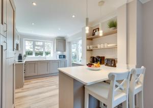 a kitchen with white cabinets and a table and chairs at 1 Lux Farm Cottages in Playford