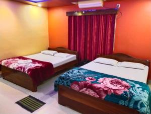 1 dormitorio con 2 camas y cortina roja en DAS HOTEL, en Darjeeling