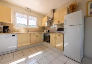 a kitchen with white appliances and a white refrigerator at Gîte L'Orée du Lac in Carcassonne