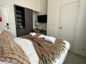 ein Schlafzimmer mit einem Bett mit einer Decke darauf in der Unterkunft Hotel Gravensteen in Gent