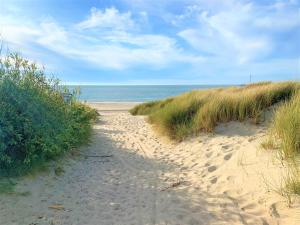 a sandy path through the grass on a beach at Houseboat Kamperland in Kamperland