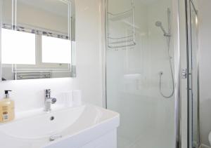 a white bathroom with a sink and a shower at 10 North Warren in Aldeburgh
