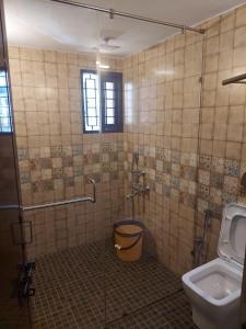 een badkamer met een glazen douche en een toilet bij Terrace abode in Mangalore
