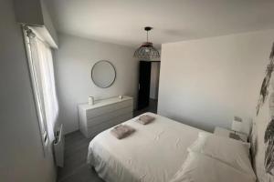 a white bedroom with a bed and a mirror at Apartment hyper-center Biarritz with parking in Biarritz