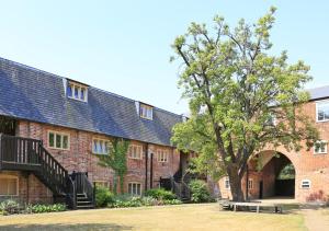 a brick building with a tree in front of it at 2 The Courtyard in Snape