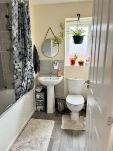 a bathroom with a toilet and a sink at House with Breath of Fresh Air in Bloxwich