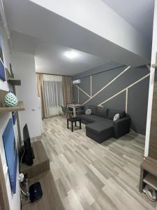ein Wohnzimmer mit einem Sofa und einem Tisch in der Unterkunft Kiraz Apartament Summerland in Mamaia