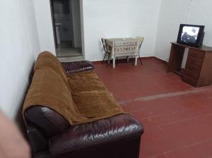 a brown blanket on a leather couch in a room at Tuc com in Durazno