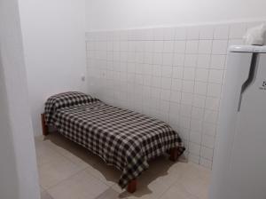 Camera piccola piastrellata di bianco con panchina in bagno di Tuc com a Durazno