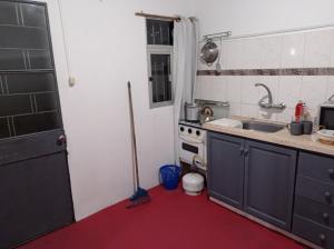 ドゥラスノにあるTuc comの赤い床とシンク付きのキッチン