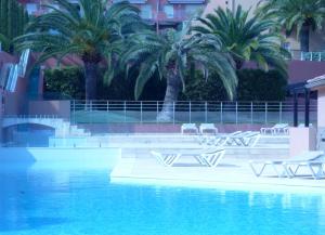 una piscina con palme e sedie accanto a un edificio di Mer, plages, piscine, paysages ydilliques:LE REVE! a Théoule-sur-Mer