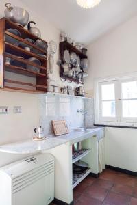 a kitchen with a counter with pots and pans on the wall at Chiara House in Levanto