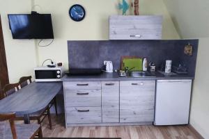a kitchen with a counter and a sink and a table at Apartament W Podkowie in Mrzeżyno