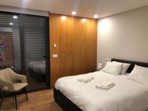 1 dormitorio con 1 cama, 1 silla y 1 ventana en Viana do Castelo - Amonde Village -Casa A * Relax, en Amonde