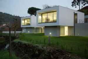 una gran casa blanca en la cima de un campo verde en Viana do Castelo - Amonde Village -Casa A * Relax, en Amonde