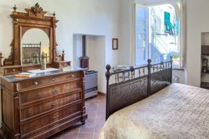a bedroom with a bed and a dresser and a mirror at Chiara House in Levanto