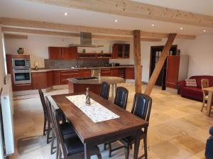 uma cozinha com uma mesa de madeira e algumas cadeiras em Michelshof em Kevelaer