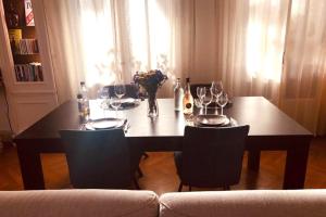 a dining table with wine glasses and a vase of flowers at Villa Iena - 4 étoiles - Proche centre ville- WIFI in Perpignan