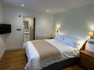 1 dormitorio con 1 cama grande y TV en Spinney on the Green en Woodhall Spa