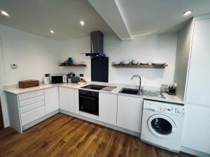 uma cozinha com um lavatório e uma máquina de lavar roupa em Spinney on the Green em Woodhall Spa
