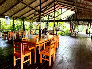 a dining area with wooden tables and chairs at Reserva Natural Natura Park in Puerto Nariño