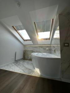 baño con bañera grande y tragaluz en Monte 27 Lux Apartments, en Sopot
