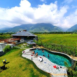 un grupo de personas en una piscina en un complejo en Osho Himalayas Wellness Resort en Kangra