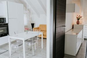 a kitchen and a dining room with a white table and chairs at La Mansarda del Sole in Ortona