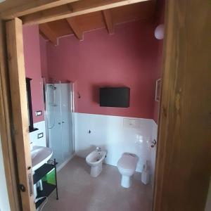 La salle de bains est pourvue de toilettes et d'une télévision murale. dans l'établissement Agricola Tre Rii Sidreria, à Corniglio
