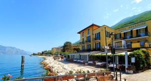 a group of buildings next to a body of water at Lake Front Hotel Brenzone in Brenzone sul Garda