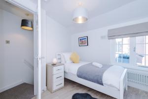 a white bedroom with a bed and a window at Stylish Home with Canal Views in Chester